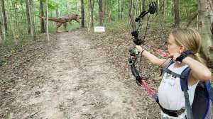 Girl shooting at 3 D dino