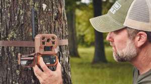 Cropped Mark Olis placing Moultrie Mobile trail camera out for scouting courtesy image