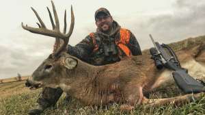 Deer hunter with big buck and rifle