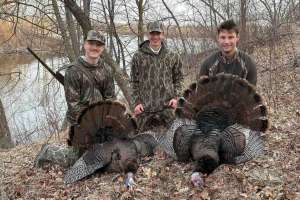 Hunters with two wild turkeys