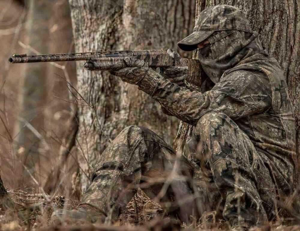 Turkey hunter aiming with shotgun